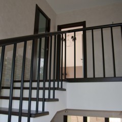 Круглый поручень и металлические трубки в ограждении лестницы